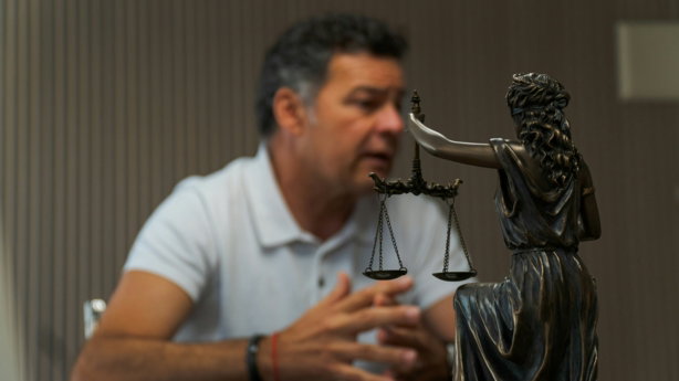 A man sitting at a table in front of a statue